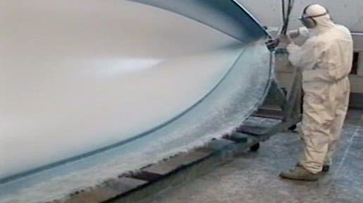 Spraying up a fibreglass boat hull in the Greymouth workshop