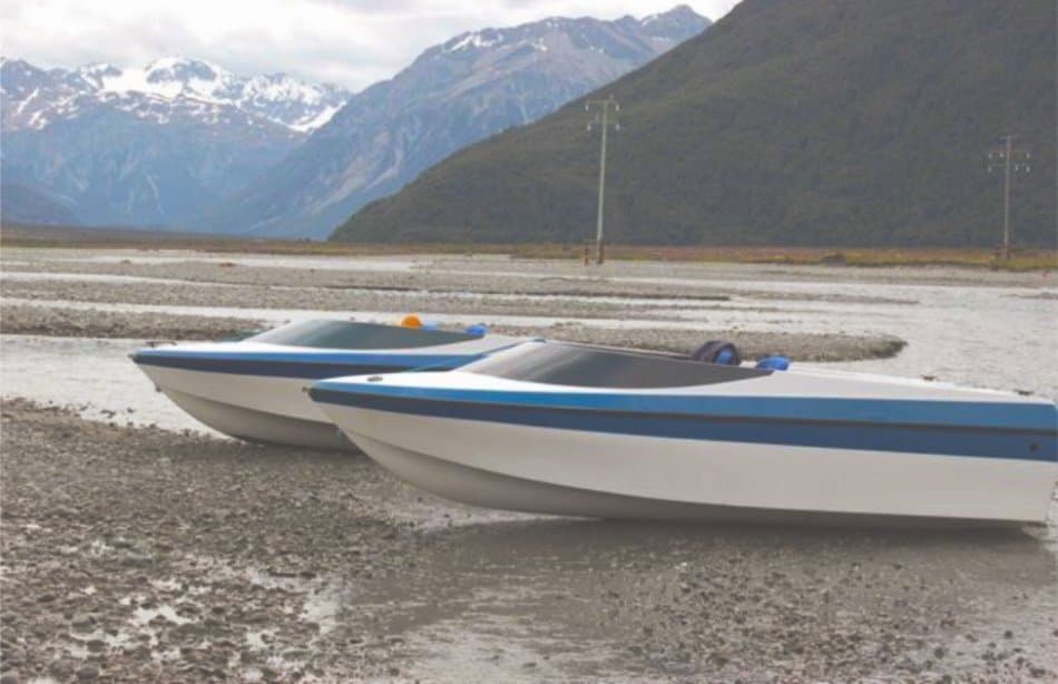 Two Terrier jet boats on the Waimakariri riverbed below snow covered mountains
