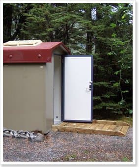 Fully accessible toilet building with a wide white door and a timber ramp
