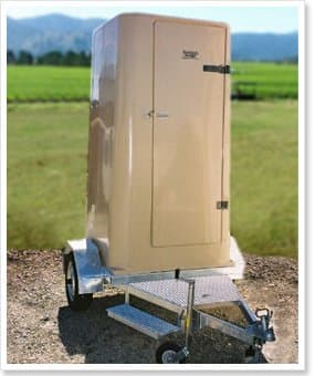 Cream NFP portable toilet mounted on a galvanised trailer beside a vineyard