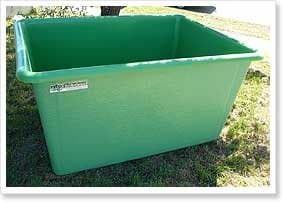 Green fibreglass viticulture picking and fermentation bin on grass